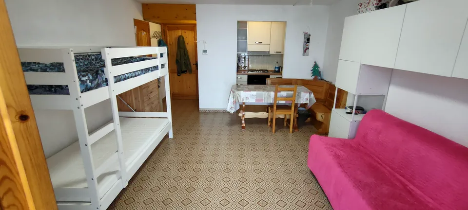 Vista dall'ingresso dell'appartamento verso la cucina e il tavolo